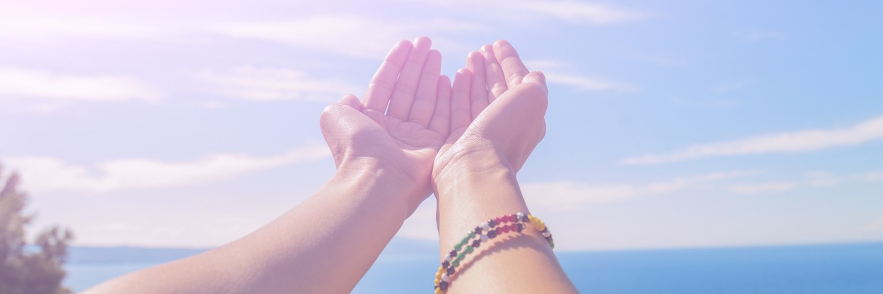 Why I'm Proud of Having Bipolar Disorder woman reaching her hand out towards the sun