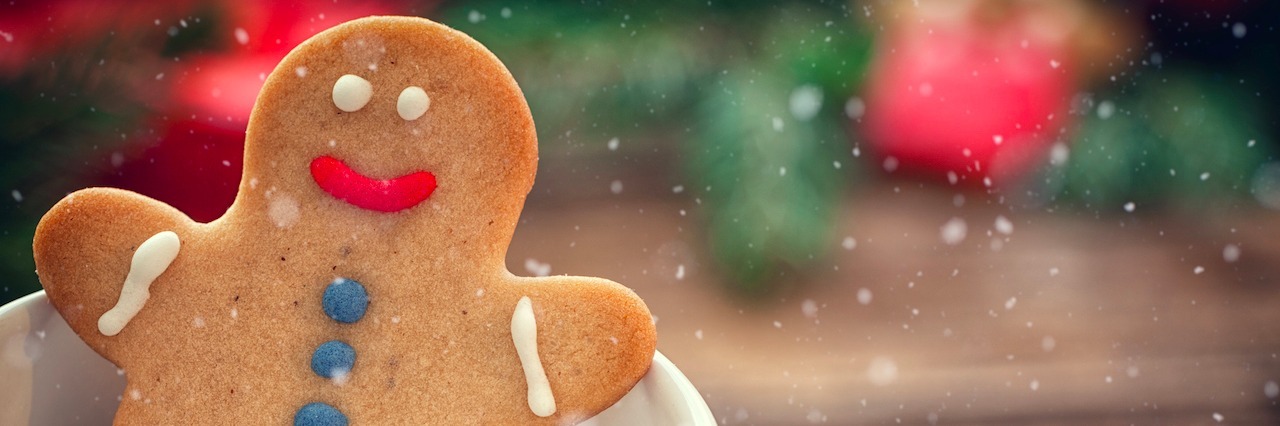 a gingerbread man sitting in a holiday mug