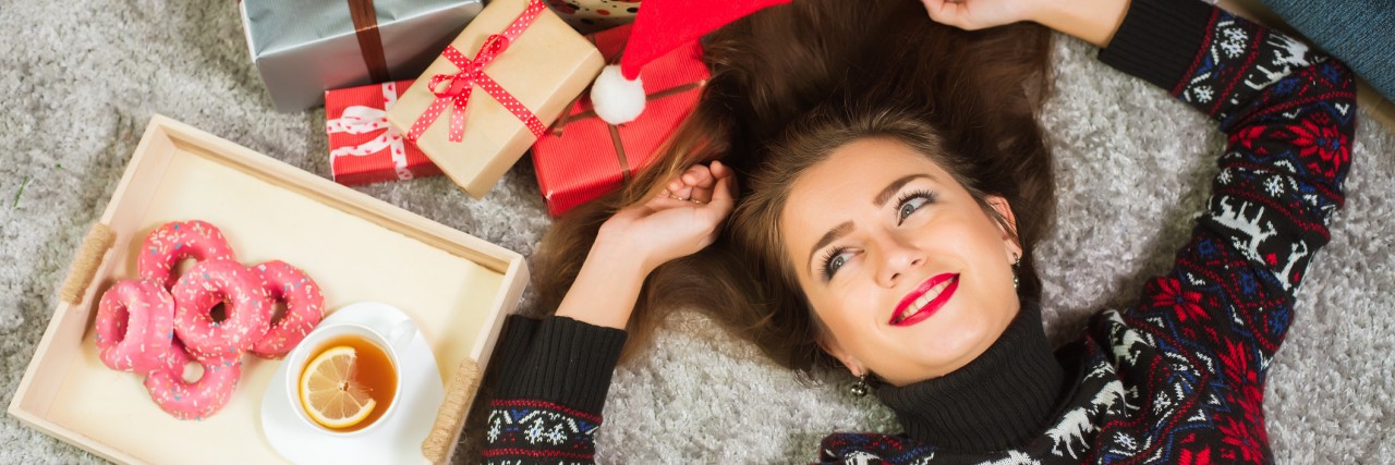 3 Tips for Surviving Holiday Dinners With Ulcerative Colitis Young cute happy girl in sweater with deer lying on