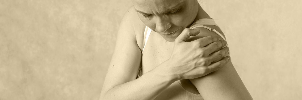 Why Is Chronic Lyme Still a 'Do-It-Yourself' Disease? Young woman has a pain in shoulder joint.