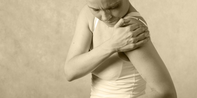 Young woman has a pain in shoulder joint.