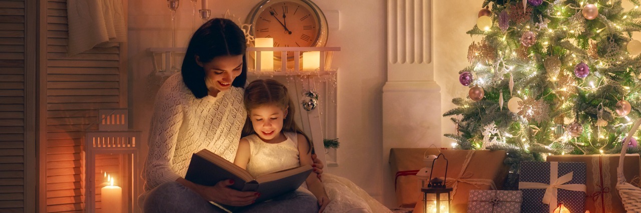 10 Tips for Getting Through the Holidays With a Chronic Illness mother reading a book in front of christmas tree