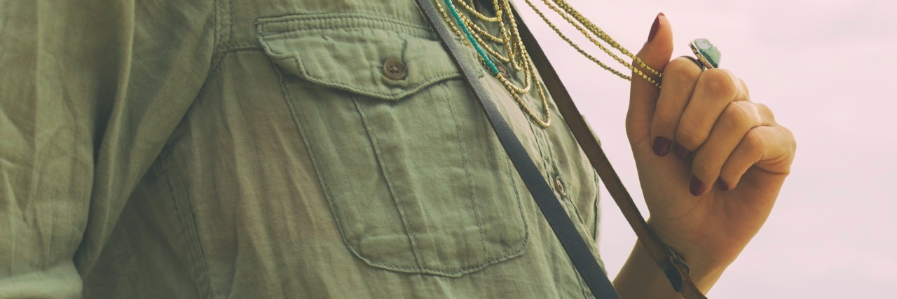 How Stimming Helps Calm Me During Times of Sensory Overload Woman holding necklace she's wearing