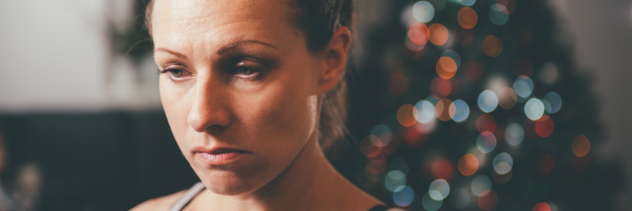 Grieving a Suicide at the Holidays Sad woman by the christmas tree
