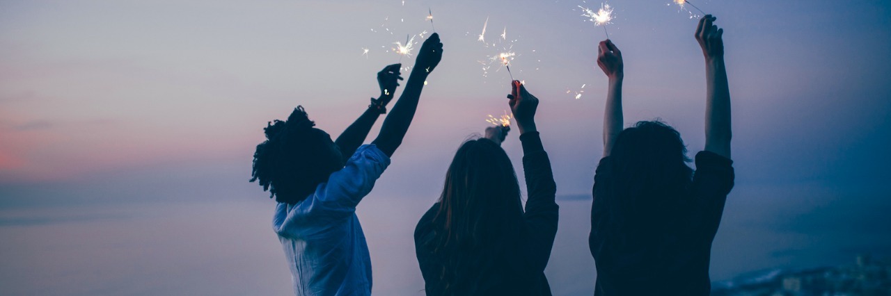 Mental Health Lessons I Learned in 2016 Three people celebrating with sparkers on a beach at night