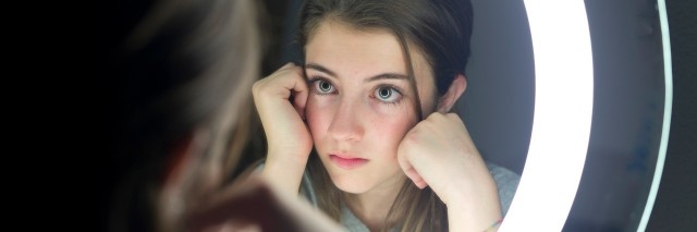 portrait of teenage looking in a mirror