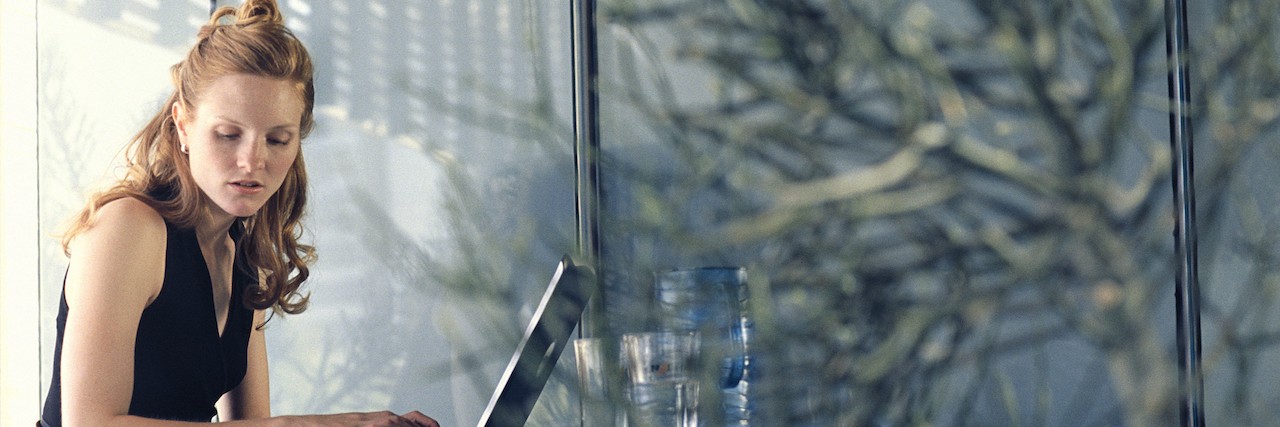 New Year's Resolution From Someone With Anxiety and Depression a woman writing at her laptop