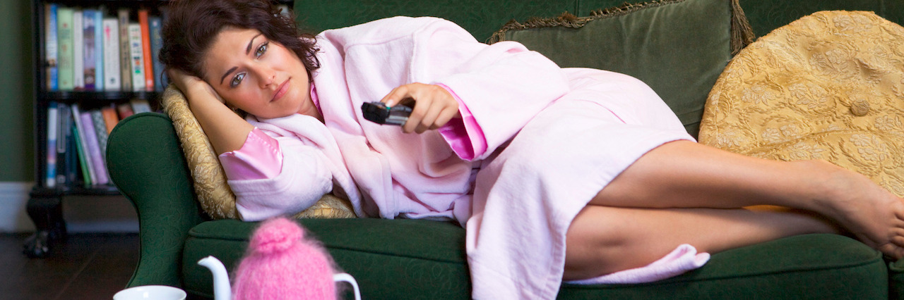 What New Years Eve Is Like for a Person With Depression Young woman lying on sofa at home watching television