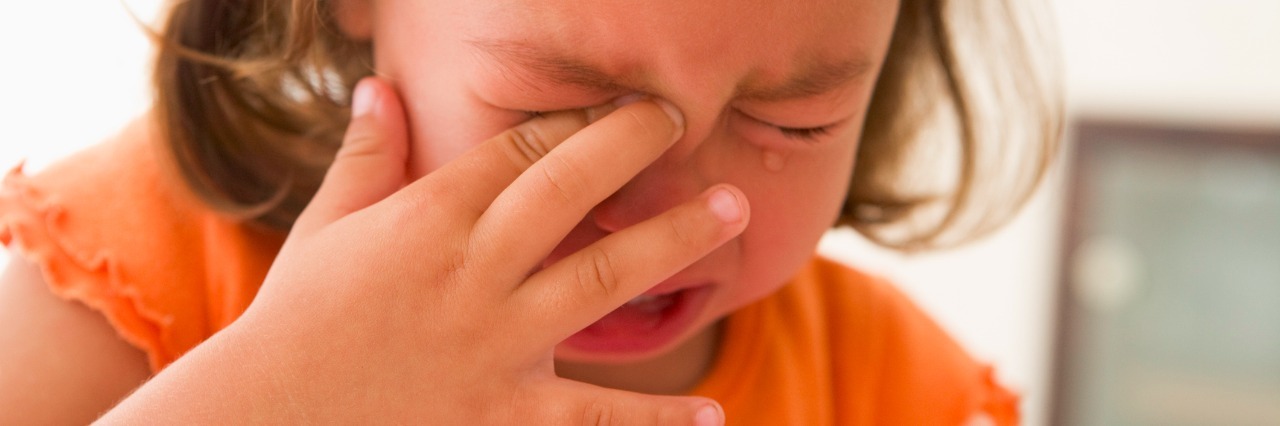 Signs of Sensory Overload and How to Calm It young girl crying and rubbing her eye
