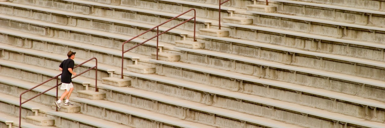8 Things I Hide as a Collegiate Athlete With Mental Illness college athlete running up empty bleachers
