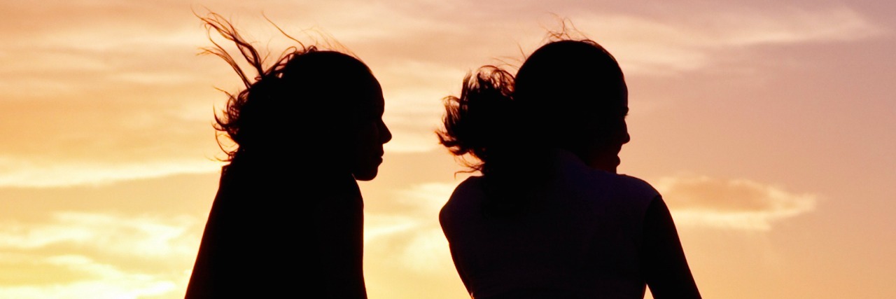Chronic Pain: Friends' Kindness and Mindfulness Makes a Difference Silhouette of two women in front of a sky at sunset