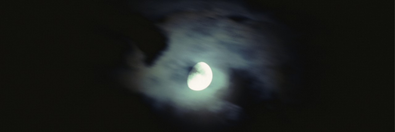 A full moon emerging from behind clouds