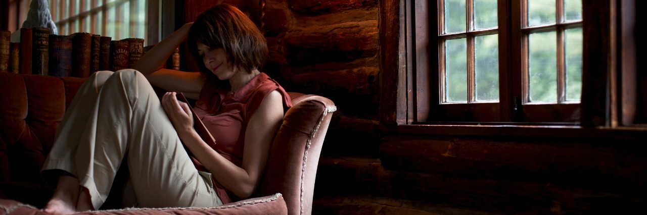 Adult on the Spectrum Shares Perspective on Autism woman sitting on sofa reading book