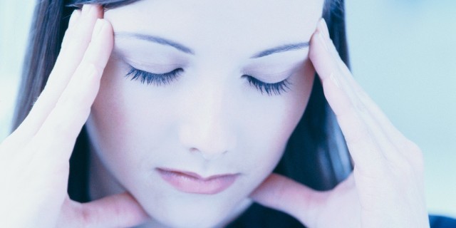 What I Wish Loved Ones Knew About My Meltdowns and Shutdowns close-up of a woman rubbing her temples with eyes closed