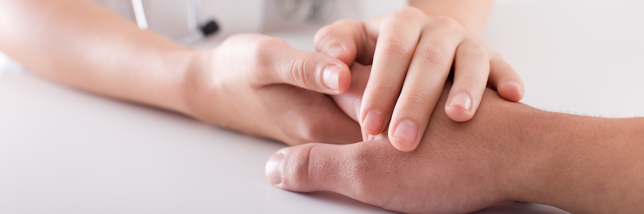 How a Moment of Kindness in a Psych Ward Saved My Life Close up of young female hands holding patient's hand as support
