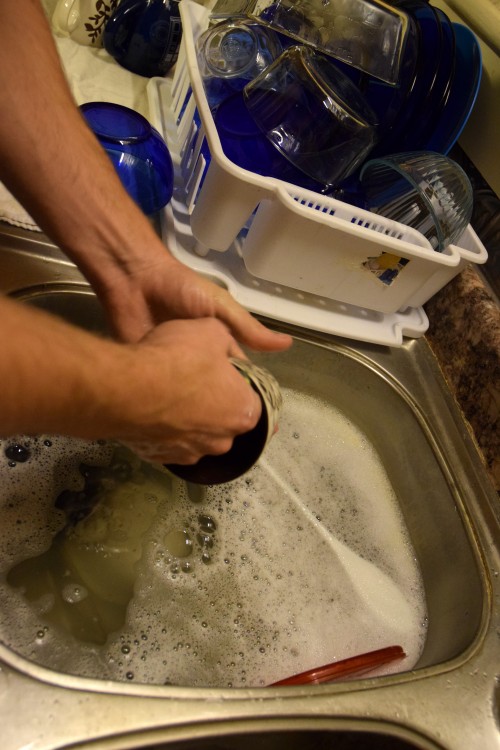 person washing dishes in the sink