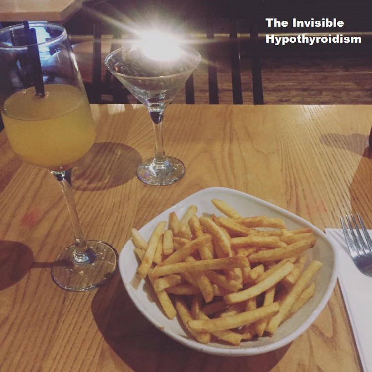 two drinks and a bowl of fries on a table at a restaurant