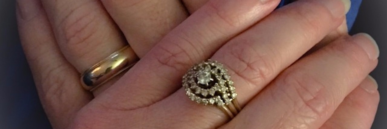 Self-Care and Preventing Burnout of Caregivers wife's hand resting on top of her husband's hand with both of their wedding rings visible