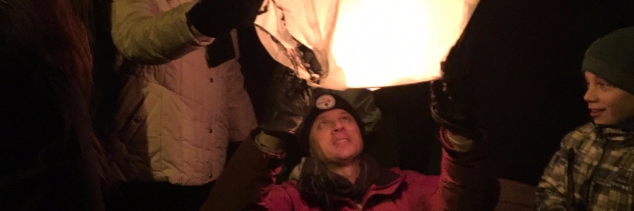 Community Remembers Child With Fireworks Party group lighting lanterns for remembrance