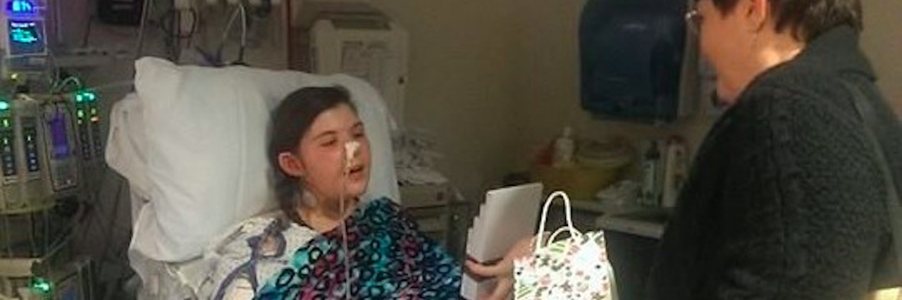 girl in hospital bed being given gifts