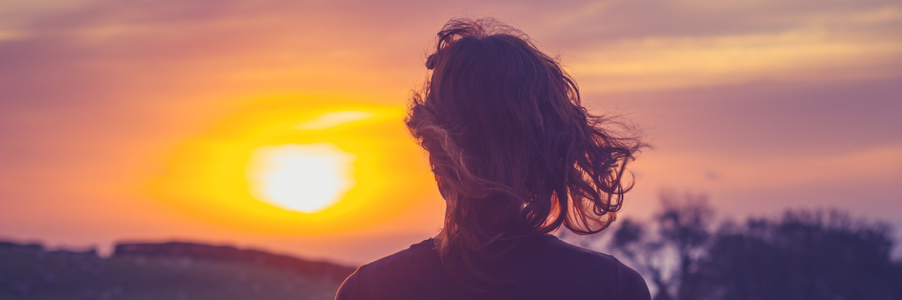 How to Help End Mental Illness Stigma by Ending Self-Stigma Rear view of young woman admiring the sunset over a field from her balcony