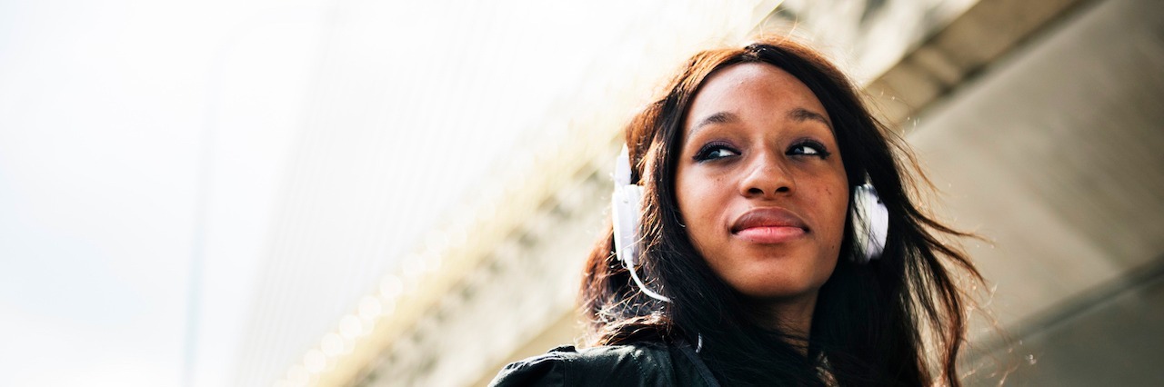 Songs to Help You Get Through a Panic Attack girl listening to music in her headphones. Text reads: 10 songs that help people take care of panic attacks