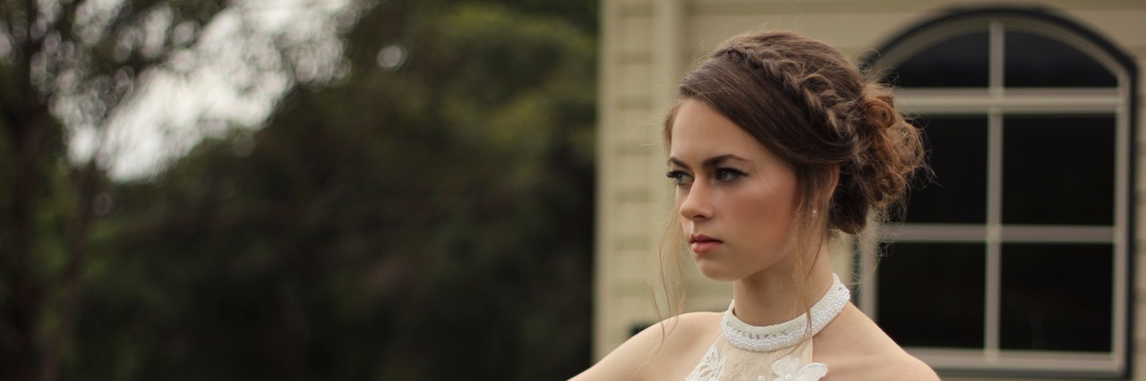 Woman Challenges Misophonia Misconceptions woman in white dress standing on a balcony