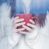 woman wearing white sweater and holding red coffee mug