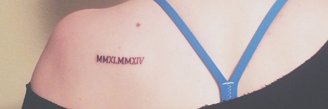 kylee's tattoo on her shoulder blade with two roman numerals of the years she had her surgeries