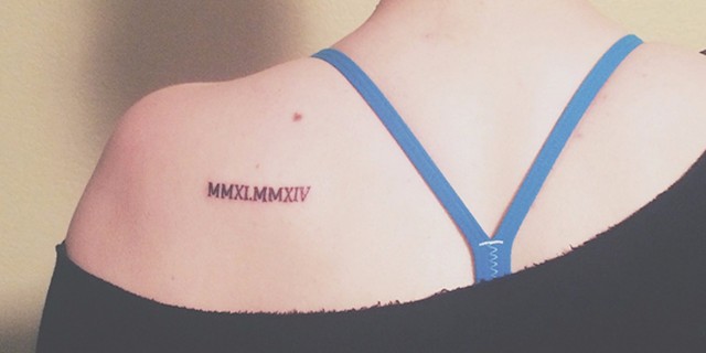 kylee's tattoo on her shoulder blade with two roman numerals of the years she had her surgeries