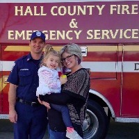 mother daughter and firefighter in front of fire truck