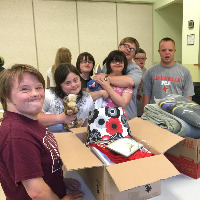 Students with Down syndrome packing refugee welcome boxes.