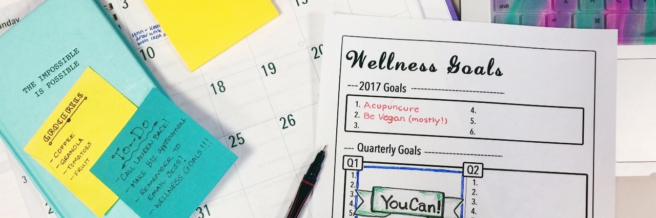 Achieving Wellness Goals With Fibromyalgia, Chronic Pain organized calendar, post it notes and wellness goals chart
