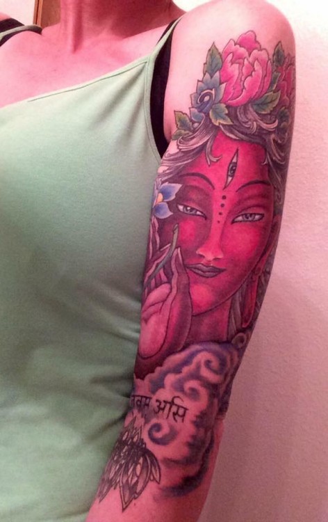 woman's arm with tattoo of woman's face in red
