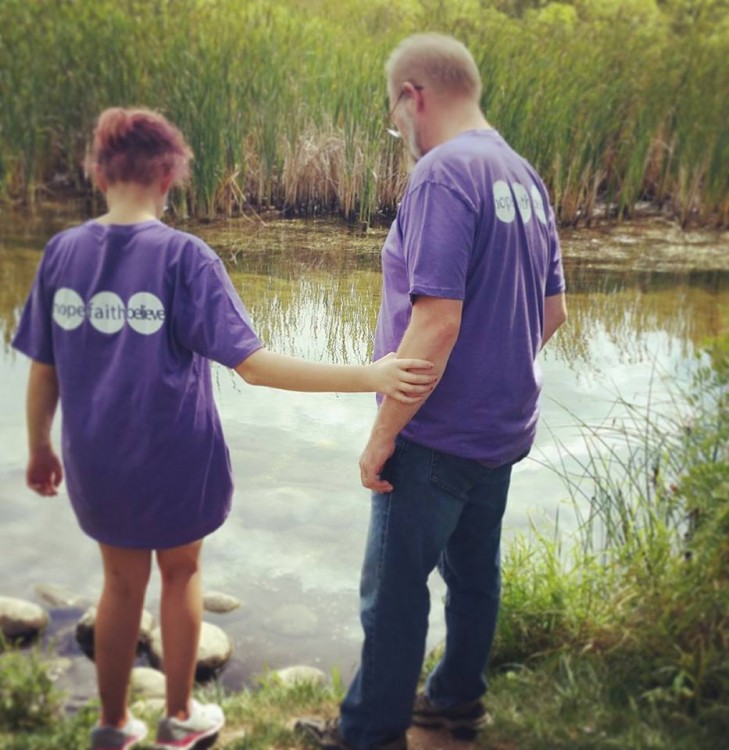 Two people standing by the water