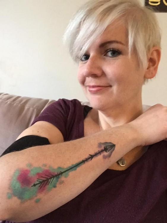 tattoo on woman's arm of arrow