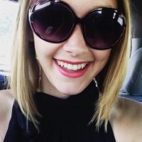 selfie of a blond woman in the car wearing sunglasses and red lipstick