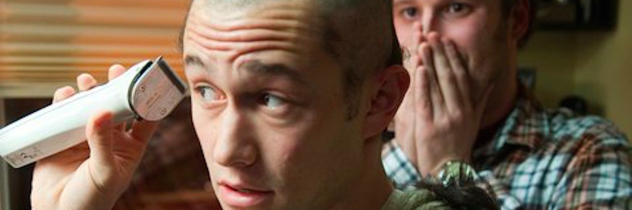 An actor in the movie "50/50" struggling with cancer shave his head with a friend watching in the background.