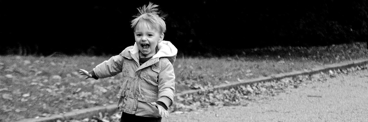 What I'm Teaching My Son as a Mom With Invisible Illness black and white photo of little boy running down road