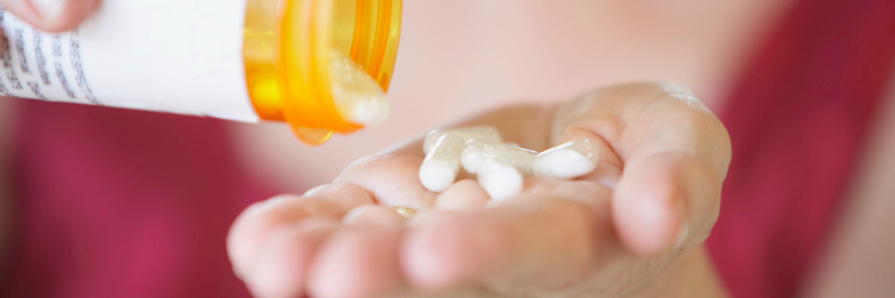 Why Choosing to Take Medicine for My Anxiety Attacks Was Hard Close-up of a person's hands holding a bottle of pills