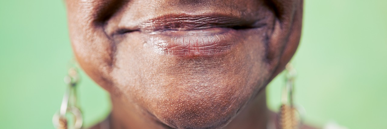 How I'm Honoring My Grandmother by Taking Care of My Mental Health Senior black woman portrait, close-up of eye and face on green background.
