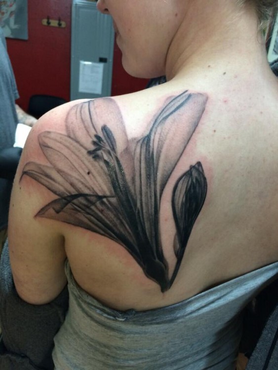 A tattoo on a woman's shoulder of an X-ray of a tattoo