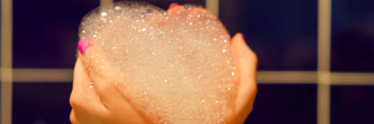 Why I Don’t Feel Guilty About Taking a Bubble Bath in My Son’s Hospital Room woman's hands holding bubble bath foam in the shape of a heart
