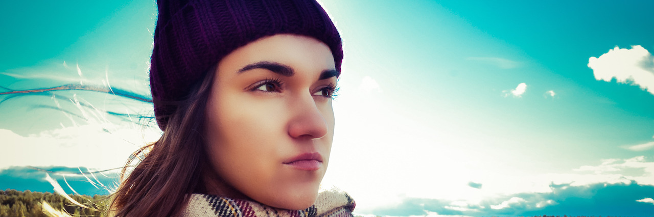 What I Learned After Having a Panic Attack on Christmas Day A girl wearing a scarf and hat standing outside in front of sunshine