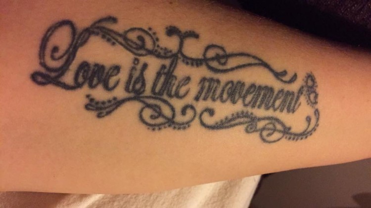 A tattoo that says, "Love is the movement."