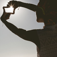 Woman frames the sunset with her hands