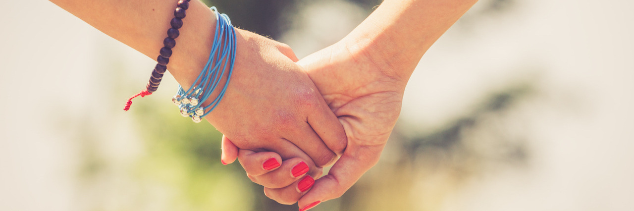 Two female friends holding hands