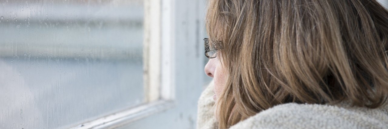 woman looking out of window on a rainy day