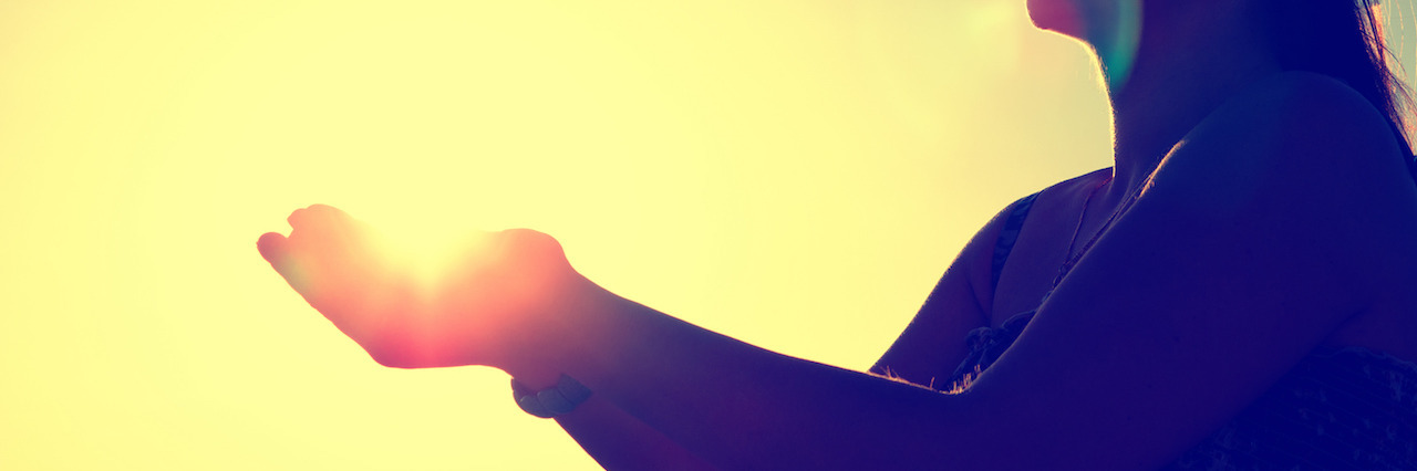 Learning to Cope With My Mental Illnesses in the New Year woman silhouette in front of a sunset