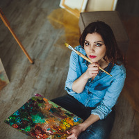 Female artist sitting with her brush and painting